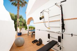 a fitness room with a wall with a gym equipment at Lovely villa with jacuzzi and heated pool in Almuñécar