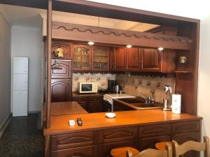 a kitchen with wooden cabinets and a wooden counter top at Central apartment in Iraklitsa