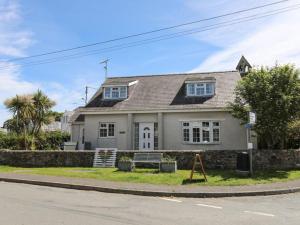 a white house on the corner of a street at Homely 4-Bed House close to stunning beach in Pwllheli