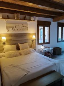 een slaapkamer met een groot wit bed en 2 ramen bij Casa Playa Loredo in Loredo