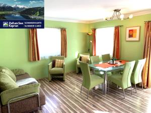 comedor con paredes verdes, mesa y sillas en Haus Schmitten – Austrian Alpine Getaways, en Zell am See