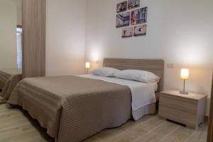 1 dormitorio con 1 cama grande y 2 lámparas en L'Affresco Affittacamere, en Campolattaro
