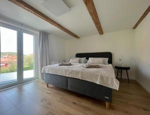 a bedroom with a bed and a large window at Ferienhaus „Am Sandstein“ in Papstdorf
