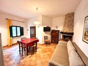 - un salon avec un canapé, une table et une cheminée dans l'établissement Agriturismo I Girasoli di Lari Appartamento indipendente 2 camere da letto, à Rivoli