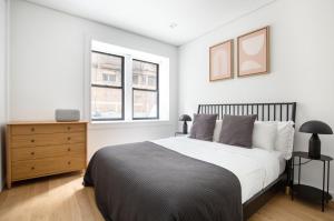 a bedroom with a large bed and two windows at SoHo 1br w outdoor space in-unit wd NYC-1142 in New York