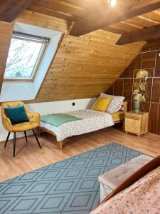 a attic bedroom with a bed and a window at Vidiecky dom AlexSandra - ubytovanie v súkromí in Liptovská Ondrašová