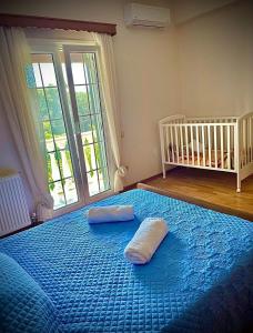a bedroom with a blue bed with two pillows on it at villamaria in Makrádes +6 photos