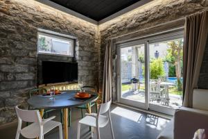 a living room with a table and chairs and a large window at Loft Favoloso con piscina in Tortolì