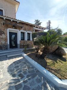 a house with a courtyard with palm trees in front of it at The Sunrise in San Teodoro