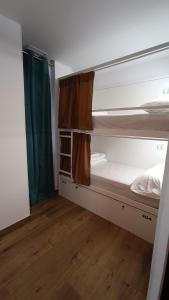a room with two bunk beds and a wooden floor at VAD HOSTEL ALICANTE in Alicante