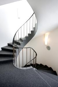 a spiral staircase in a house with a round mirror at Eiðar - Hostel in Egilsstaðir