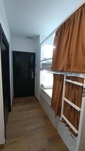 a small room with a refrigerator and a wooden floor at VAD HOSTEL ALICANTE in Alicante