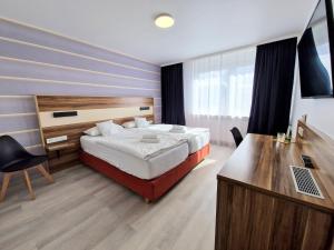 1 dormitorio con 1 cama y escritorio con ordenador portátil en Hotel am Kurpark, en Bad Wimpfen