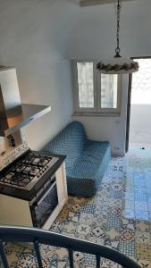 a kitchen with a stove and a couch in a room at Petit Maison Jeranto in Nerano