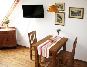 una sala da pranzo con tavolo in legno e TV di Farma Mošna a Zbytiny