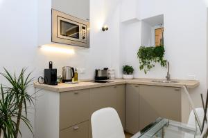 a small kitchen with a sink and a microwave at Cozy & Central with Private Entrance - NDP Rent in Rome