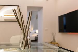 a glass vase with sticks in it on a glass table at Cozy & Central with Private Entrance - NDP Rent in Rome
