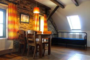 a dining room with a table and chairs and a bed at Farma Mošna in Zbytiny