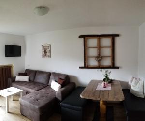 een woonkamer met een bank en een tafel bij Alpin Appart Reiterhof in Niederthai