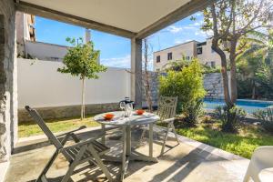 a table and chairs on a patio with a pool at Loft Favoloso con piscina in Tortolì