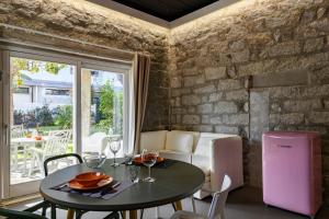 uma mesa e cadeiras num quarto com uma parede de tijolos em Loft Favoloso con piscina em Tortolì