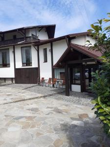 ein Haus mit einer Terrasse davor in der Unterkunft NO COMMENT RUSTIC in Curtea de Argeş