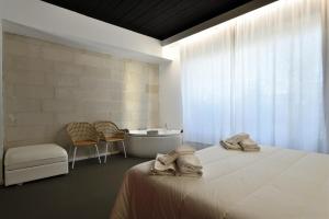 a bedroom with a bed and a tub and a sink at Loft Favoloso con piscina in Tortolì +24 photos