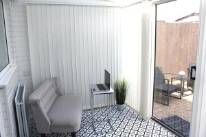 a balcony with a chair and a television on a patio at Gorgeous 3 bed House In Milton Keynes in Bletchley