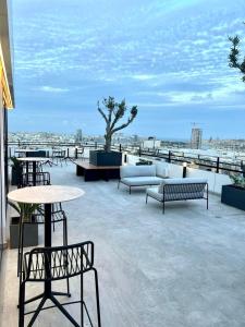 a patio with benches and tables and a view of the beach at Park Heights by the Warren Collection in Msida