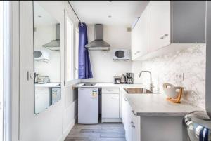 a white kitchen with white cabinets and a sink at Studio 4pers#Malesherbes#Parc Monceau in Paris