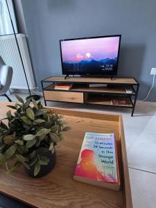 a book sitting on a coffee table in front of a tv at Zoe Apartment in Kavála