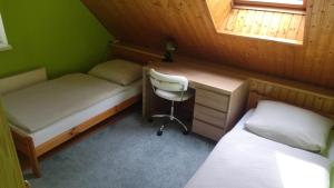 1 dormitorio con 2 camas, escritorio y silla en Dovolenkovy dom, en Ružomberok