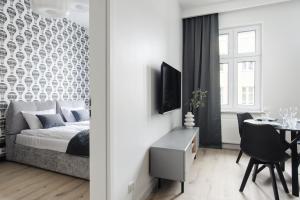 ein Schlafzimmer mit einem Bett und ein Esszimmer mit einem Tisch in der Unterkunft Manpro Apartments Toruń in Toruń