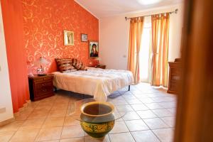 a bedroom with a bed with orange walls at Lo Zio Michele Apartments in Nuova Gibellina