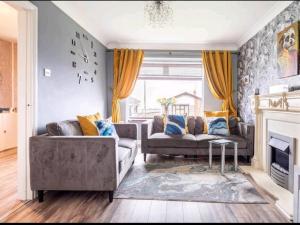 a living room with two couches and a fireplace at Spacious house City skyline and mountain views close too belfast centre and airports free parking in Belfast