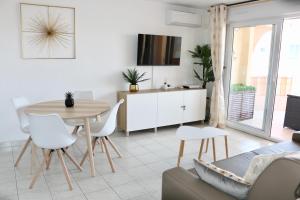 弗雷瑞斯的住宿－Port-Fréjus, LE CONSUL, appartement 2 pièces climatisé, terrasse & parking，厨房以及带桌椅的起居室。
