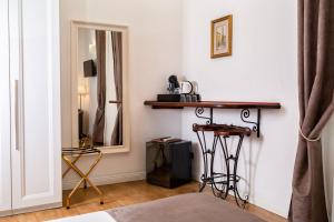 B&B Chez Moi في بولونيا: غرفة نوم مع مرآة وطاولة وكراسي