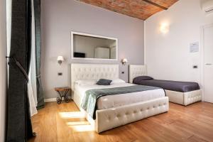 1 dormitorio con cama blanca y espejo en B&B Chez Moi, en Bolonia