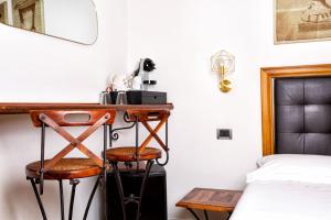 a bedroom with a desk and a bed and a bed and stool at B&B Chez Moi in Bologna