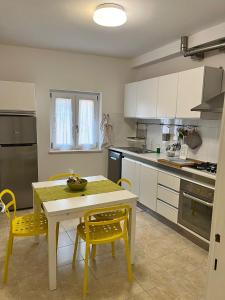 eine Küche mit einem Tisch und gelben Stühlen in der Unterkunft CoreHome in Albano Laziale
