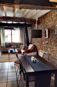 sala de estar con mesa y pared de piedra en Casa el Envero en Saro