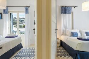 Dos camas en una habitación con ventana. en Mykonos Perla Town House, en Mykonos ciudad 28 fotos más