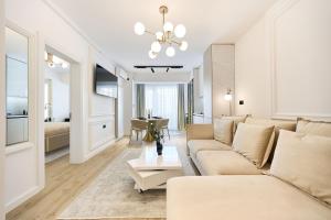 sala de estar con sofá y mesa en Infinity Everglow Apartment Spa&Pool Beach Resort-parking en Mamaia