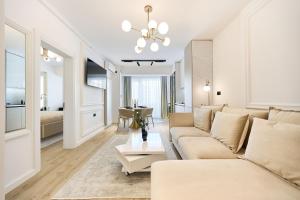 una sala de estar con un sofá y una mesa en Infinity Everglow Apartment Spa&Pool Beach Resort-parking, en Mamaia