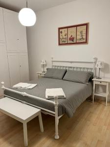 een slaapkamer met een bed en twee tafels en een lamp bij CoreHome in Albano Laziale
