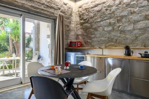 een keuken met een tafel en stoelen en een raam bij Loft incantevole con piscina in Tortolì