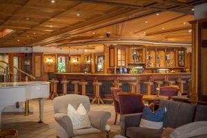 a bar with a white piano in a room at MANNI das Hotel in Mayrhofen