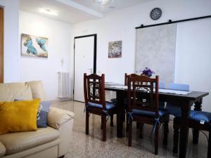 uma sala de estar com uma mesa e cadeiras e um sofá em Appartamento vacanze Assisi nel cuore em Costano