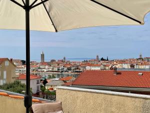 a view of a city from a balcony with an umbrella at Apartments Maričić Banjol in Rab