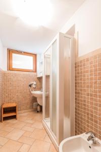 ein Bad mit einem Waschbecken, einer Dusche und einem WC in der Unterkunft La Filanda Apartments by Wonderful Italy - Cotone in Bellagio